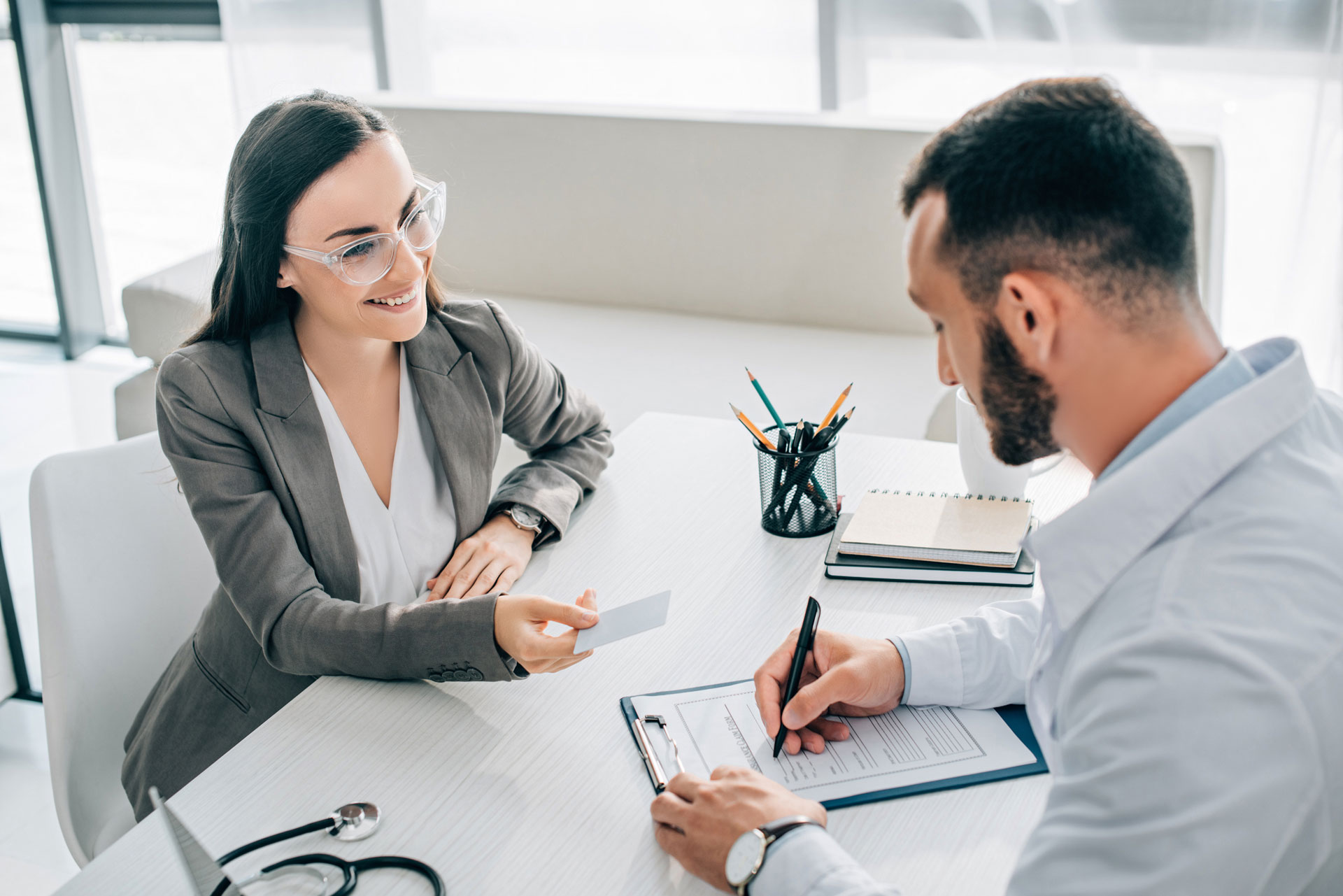 Medical office manager collaborates with health insurance representative depicting insurance collaboration