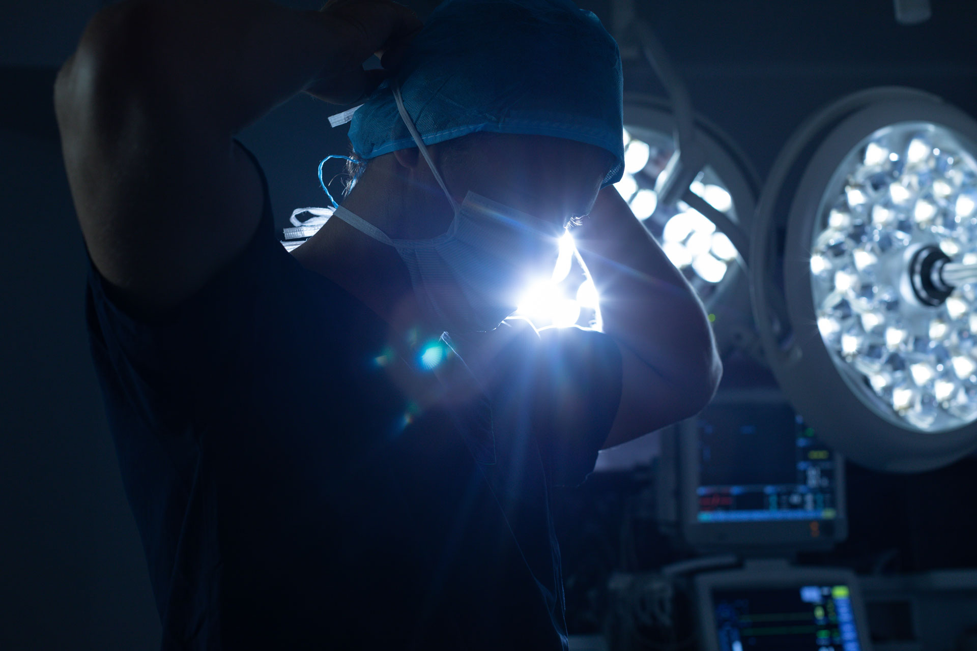 doctor putting on face mask in operating room